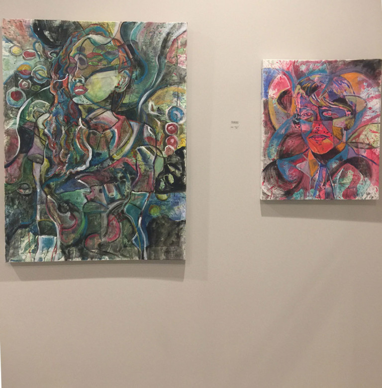 Two paintings by Jason Stallings at a private art opening in 2017. "13th floor" is on the left while a portrait of Paul McCartney is on the right.